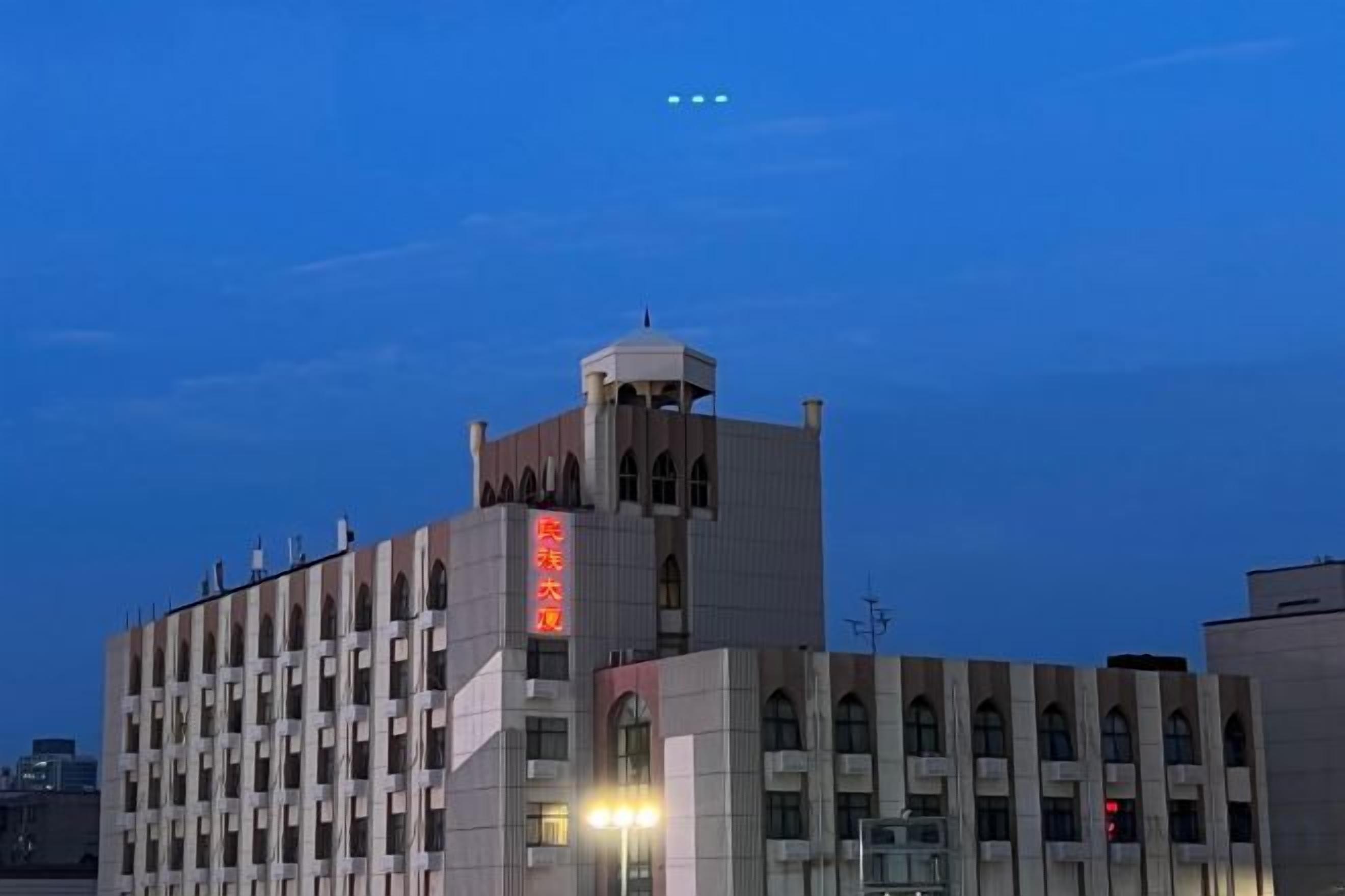 A multi-story building with a prominent tower and a sign with red characters.