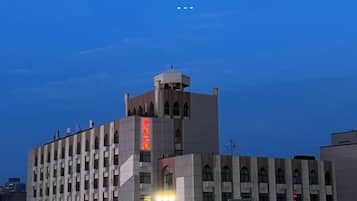 A multi-story building with a prominent tower and a sign with red characters.