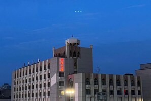 A multi-story building with a prominent tower and a sign with red characters. - Minzu Building Express Hotel (Zhengzhou Zijing Shandong Street Subway Station) (Zhengzhou)