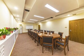 A conference room with a long table, chairs, a whiteboard, and potted plants. - Minzu Building Express Hotel (Zhengzhou Zijing Shandong Street Subway Station) (Zhengzhou)