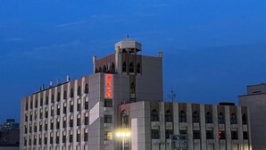 Un edificio con una torre imponente e un cartello con caratteri cinesi.