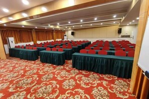 A conference room with rows of tables and chairs, a patterned carpet, and a speaker system. - Minzu Building Express Hotel (Zhengzhou Zijing Shandong Street Subway Station) (Zhengzhou)