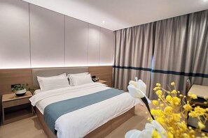 A modern hotel room with a large bed, bedside tables, a nightstand, and a view of the city. - Minzu Building Express Hotel (Zhengzhou Zijing Shandong Street Subway Station) (Zhengzhou)