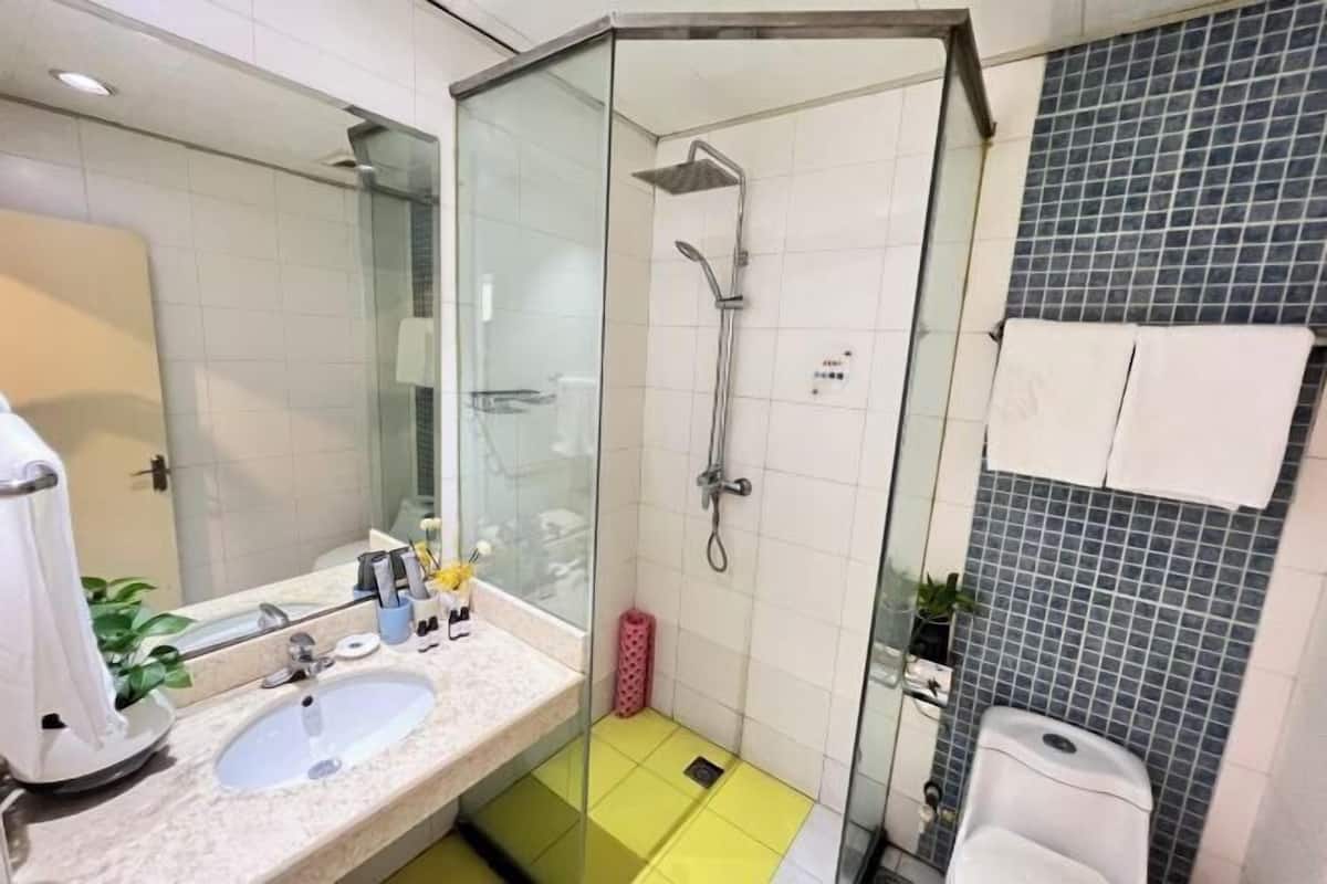 Une salle de bain moderne avec une douche à parois de verre, un lavabo et des toilettes.