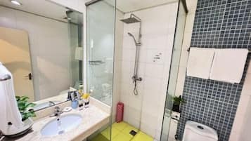 A modern bathroom with a glass-enclosed shower, a sink, and a toilet.