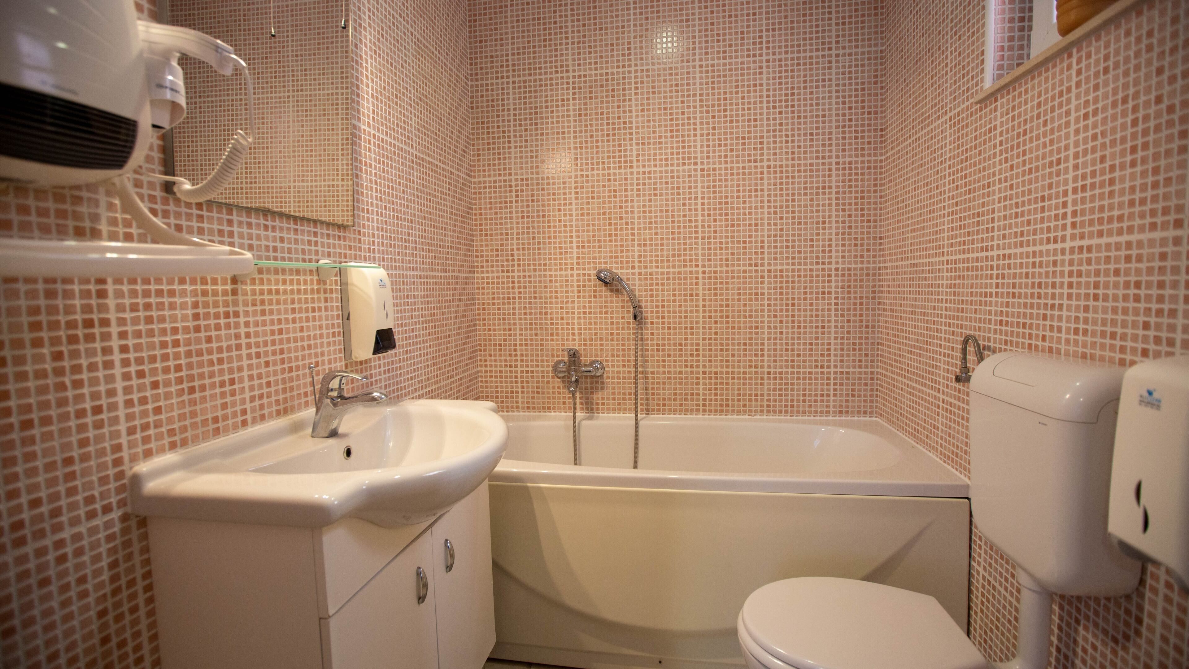 A bathroom with a sink, toilet, and bathtub.