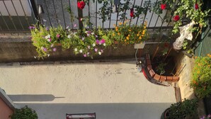 A rooftop terrace with a table and chairs, surrounded by potted plants and flowers. - Pansion Boris Međugorje (Citluk)