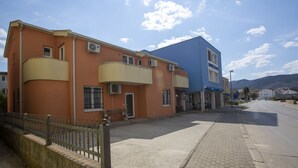 A two-story building with a flat roof, a balcony on the second floor, and an air conditioning unit on the exterior wall. - Pansion Boris Međugorje (Citluk)