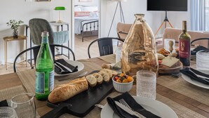 Un comedor con una araña, una mesa dispuesta para una comida y un televisor al fondo.