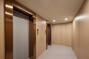 A narrow hallway with two elevators and a carpeted floor. - Yuejia Hotel (Xuancheng Jingtingshan Branch) (Xuancheng)