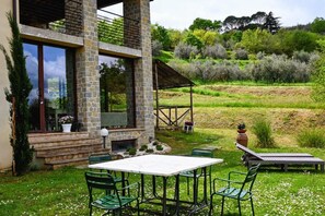 A stone building with a balcony, outdoor seating, and a garden with flowering trees. - TUSCANY DETACHED HOUSE INCREDIBLE PANORAMA, LARGE GARDEN 5 MIN FROM AREZZO (Toscana)