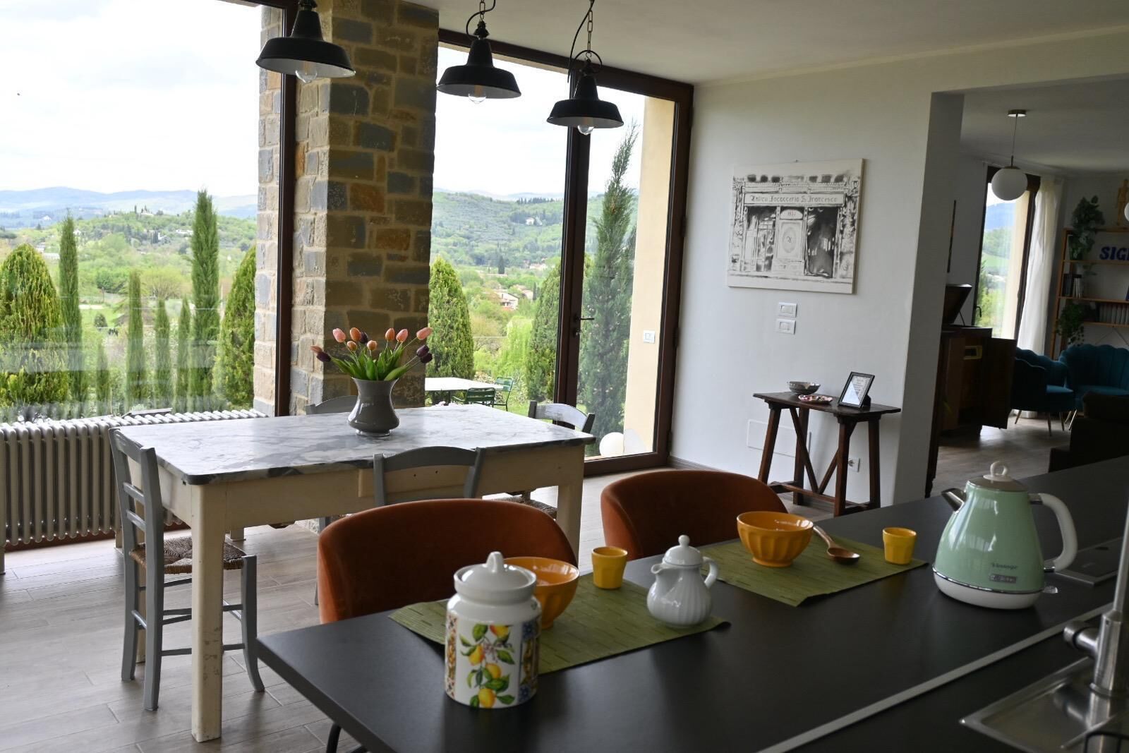 Un espace repas comprenant une table, des chaises et une vue sur la campagne.