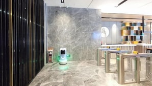 A modern hotel lobby with a marble floor, a self-service kiosk, and a reception desk. - Echarm Hotel (Guangzhou Beijing Road Pedestrian Street Tianzi Pier) (Guangzhou)