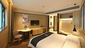 A hotel room with a bed, desk, chair, TV, and a bedside table. - Echarm Hotel (Guangzhou Beijing Road Pedestrian Street Tianzi Pier) (Guangzhou)