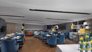 A modern hotel lobby with blue seating, wooden flooring, and a central decorative feature. - Echarm Hotel (Guangzhou Beijing Road Pedestrian Street Tianzi Pier) (Guangzhou)