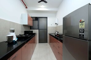 A kitchen with stainless steel appliances, a microwave, a kettle, and a toaster.