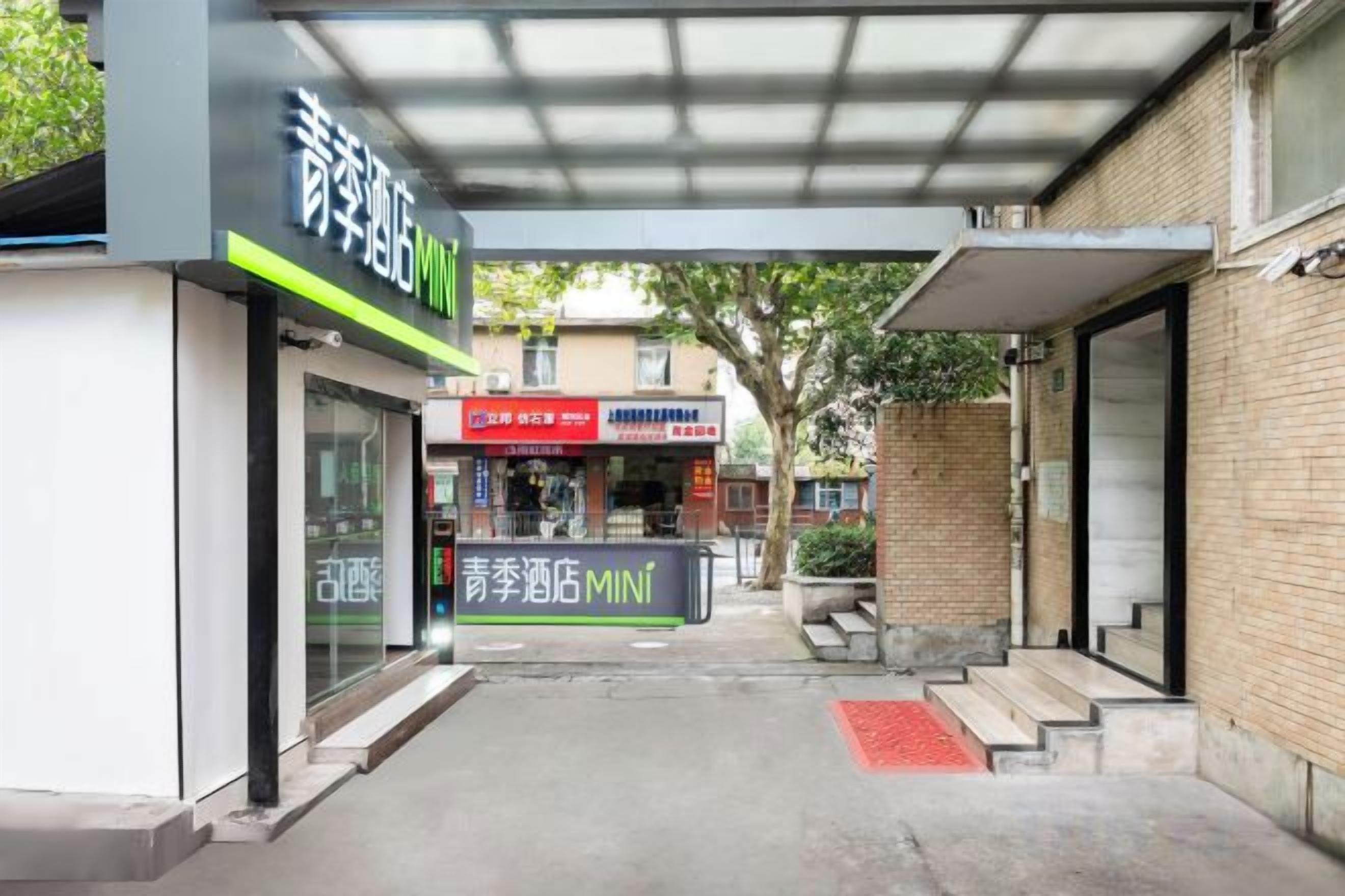 A building entrance with a covered walkway, a sign for a store, and a visible staircase.