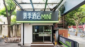 Entrada de un hotel con un letrero que dice "青季酒店 MINI".