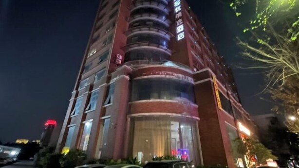 Un hotel de varios pisos con una entrada destacada y balcones.