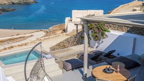 A rooftop terrace with a pool, outdoor seating, and a view of the sea. - Mykonist Merchia Beach Villas & Suites (Mykonos)