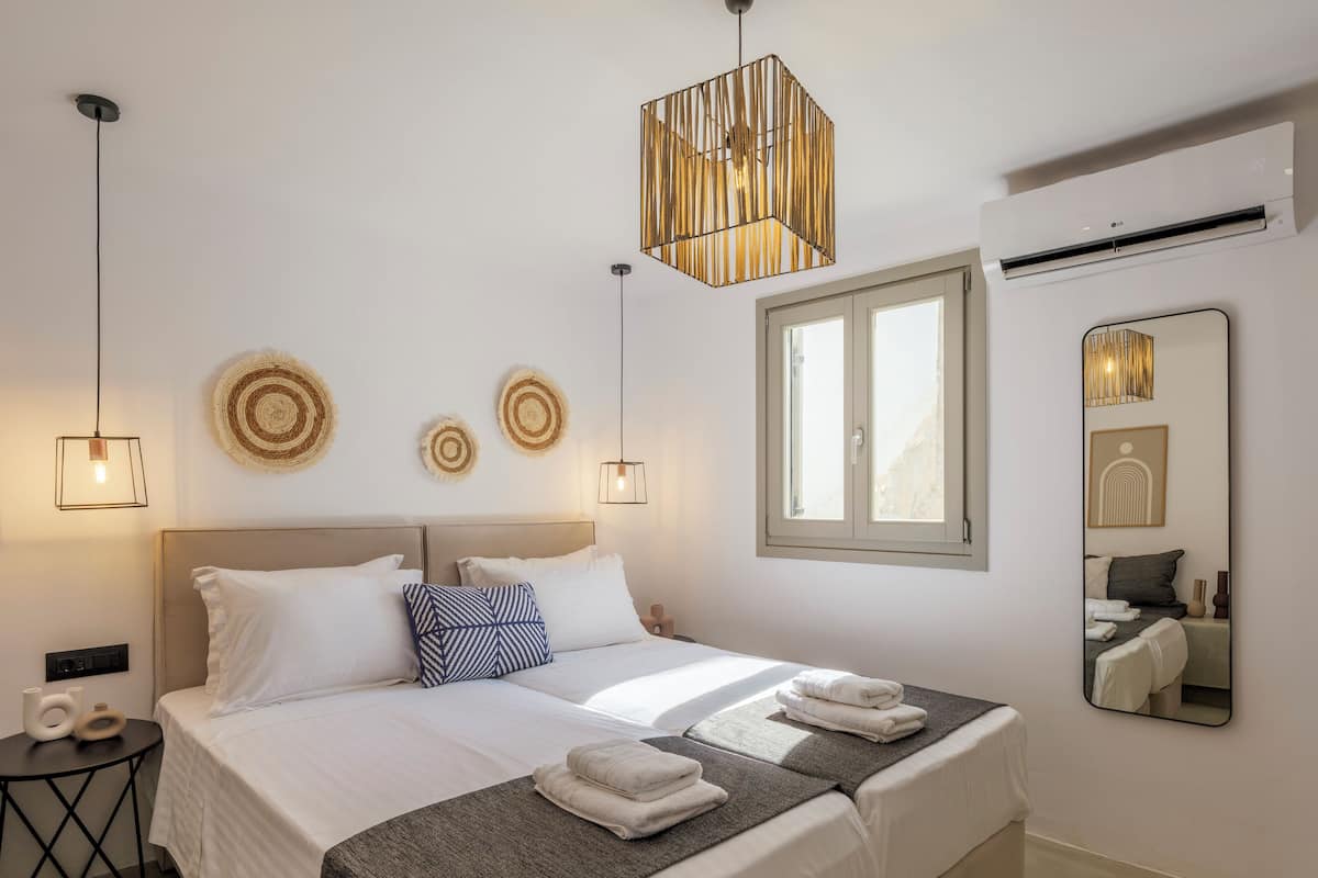Un dormitorio moderno con una cama grande, mesitas de noche, un espejo y decoración mural.