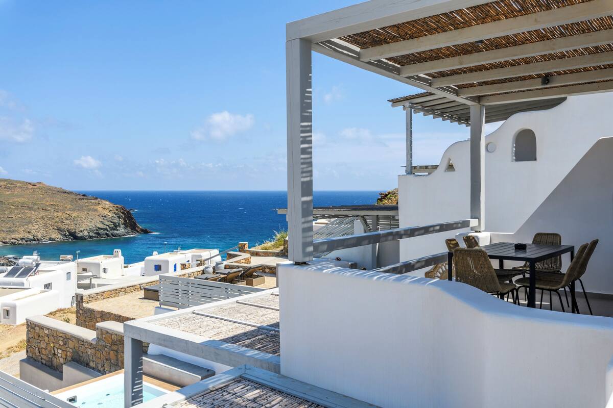 Una terraza con mesa y sillas con vistas al mar.