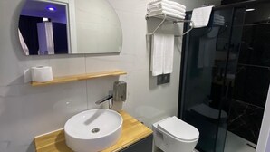 A modern bathroom with a round sink, a toilet, and a glass shower enclosure. - Gebze Kent Pansiyon (Gebze)
