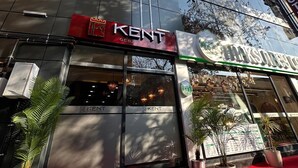 A modern building with a 'KENT' sign, a red carpet entrance, and potted plants. - Gebze Kent Pansiyon (Gebze)