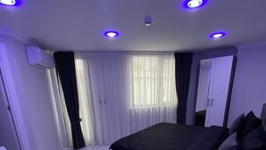 A modern bedroom with a large bed, a desk, and a wardrobe. - Gebze Kent Pansiyon (Gebze)