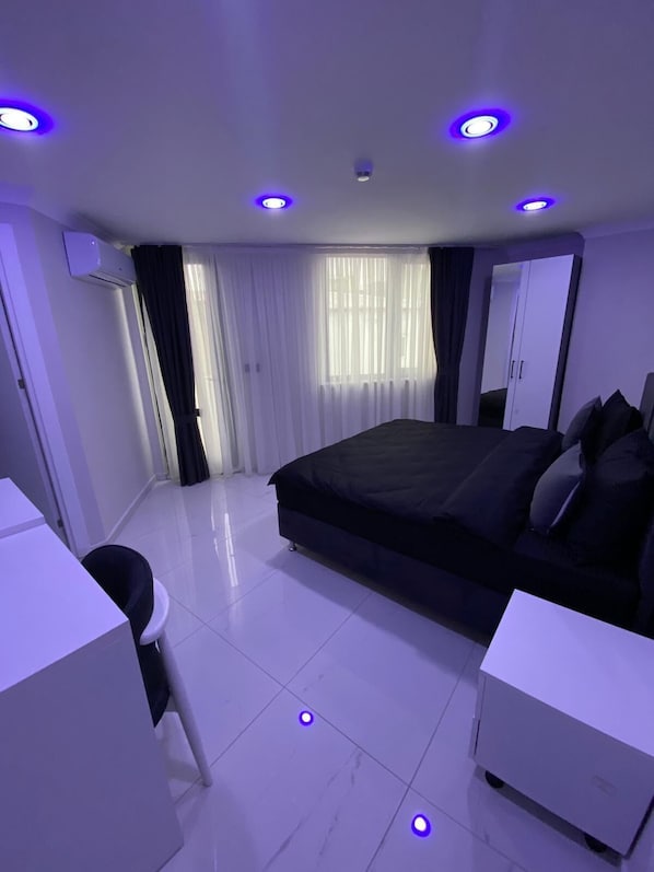 A modern bedroom with a large bed, a desk, and a wardrobe. - Gebze Kent Pansiyon (Gebze)