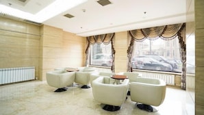 A modern lounge with white leather chairs and tables, large windows with curtains, and a marble floor. - 1896 Hotel (Dalian Railway Station Russian Style Street Store) (Dalian)