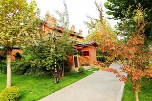 A brick building with a red roof, a paved pathway, and surrounding greenery. - 1896 Hotel (Dalian Railway Station Russian Style Street Store) (Dalian)