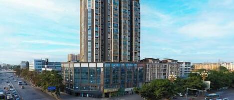 Un edificio de varios pisos con un diseño arquitectónico moderno, que combina fachadas de vidrio y hormigón.