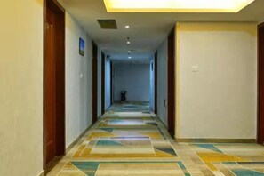 Stylish hotel corridor with a geometric patterned floor and recessed lighting.