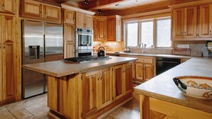 A spacious kitchen with wooden cabinets, stainless steel appliances, and a large island. - Perfect for your Large Group!  Amazing Outdoors-4th nt. FREE in August! (Valdez)