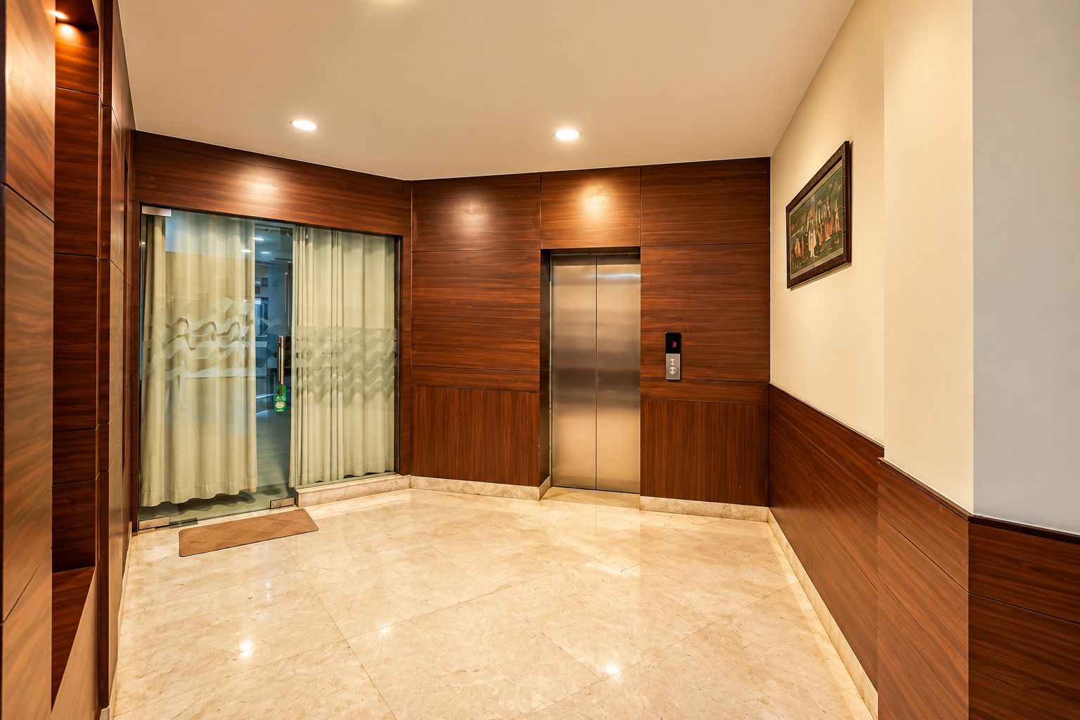 A modern elevator with a control panel, a wooden wall panel, and a marble floor.