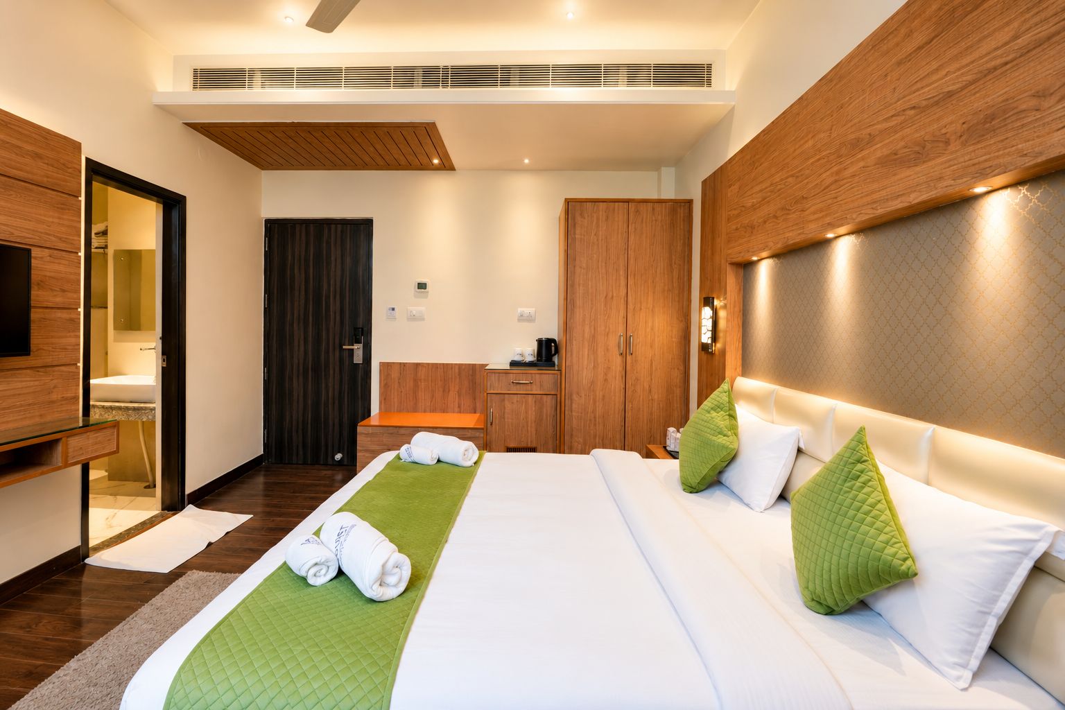 Habitación de hotel con cama, escritorio, armario y baño.