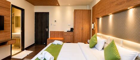 Habitación de hotel con cama, escritorio, armario y baño.