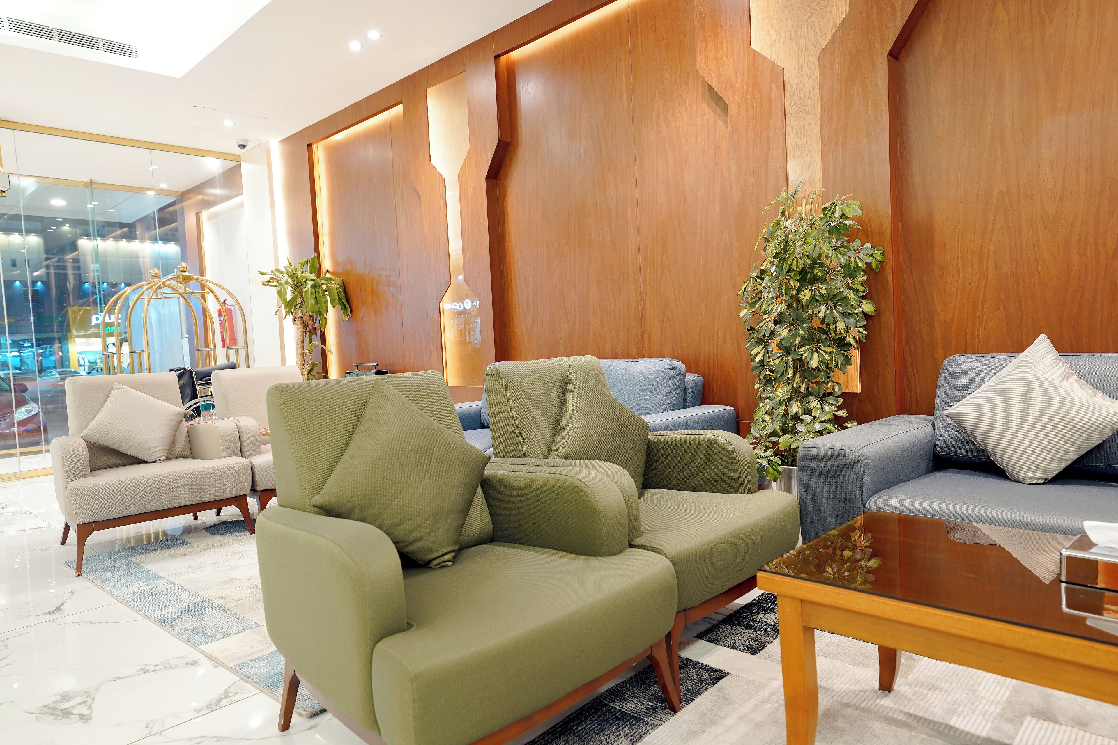 Eine moderne Lobby mit einem grünen Sofa, einem blauen Sofa und einem Holztisch.