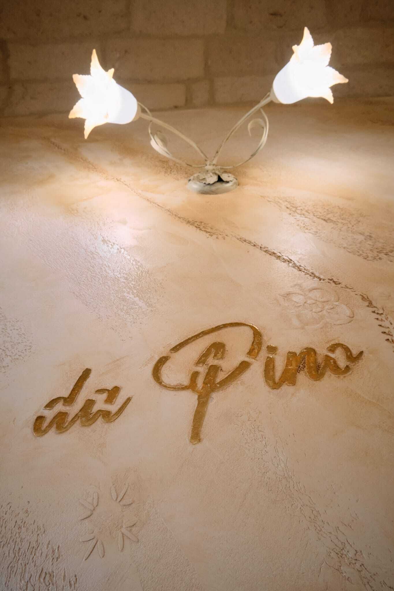 Une table surmontée d’un luminaire et portant l’inscription « da Pino ».