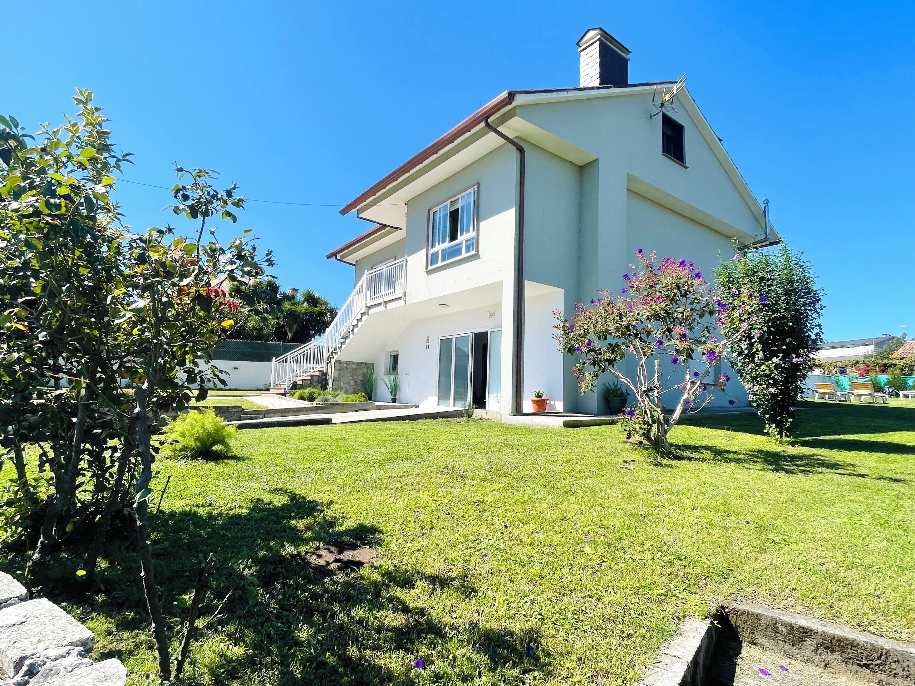 Une maison à deux étages dotée d’un balcon, d’une allée pavée et d’une pelouse bien entretenue.