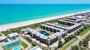 Un complexe hôtelier comprenant plusieurs bâtiments, une plage et un espace piscine.