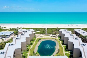 Ein Resort mit mehreren Gebäuden, einem zentralen Wasserspielplatz und Blick auf den Strand.