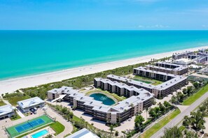 Ein Resort mit mehreren Gebäuden, einem Strand und einem Poolbereich.