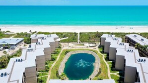 Un complexe hôtelier comprenant plusieurs bâtiments, une fontaine centrale et offrant une vue sur la plage.