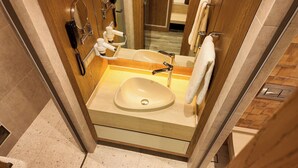 A modern bathroom with a large sink, a mirror, a hairdryer, and a towel rack. - Rempart Hotel (Diyarbakir)