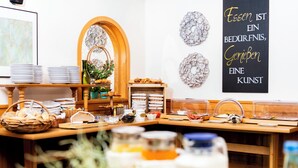 Un montaje tipo buffet con platos, cestas y recipientes de comida.