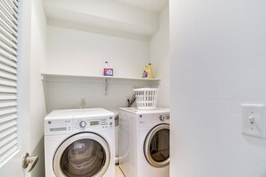 A laundry room with two front-loading washing machines, a shelf with laundry detergent, and a white laundry basket. - 1 Mi to Old Town: Philadelphia Townhome w/ Patio! (Philadelphia)