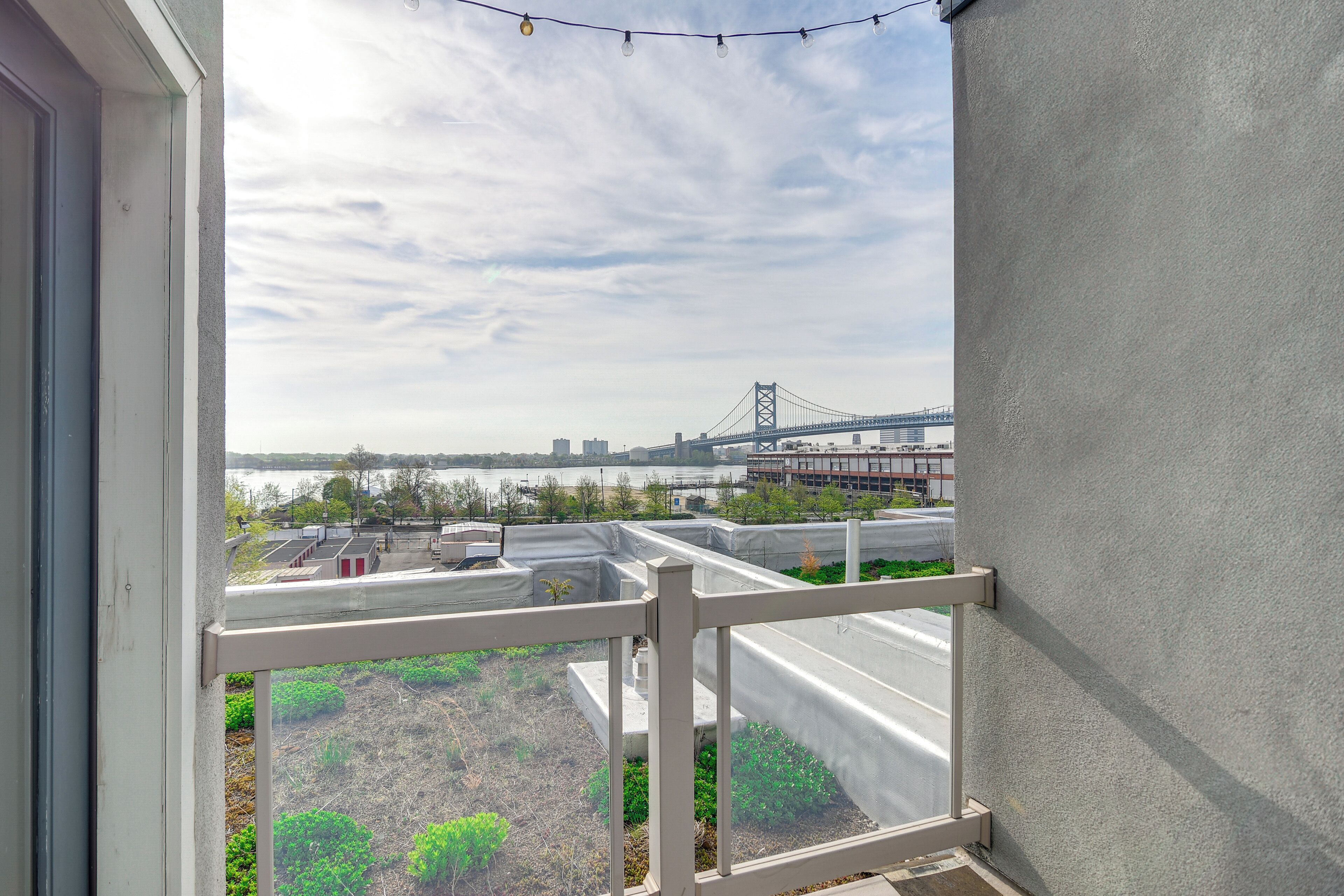 A balcony with a view of a bridge and buildings across a body of water.