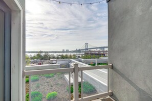 A balcony with a view of a bridge and buildings across a body of water.